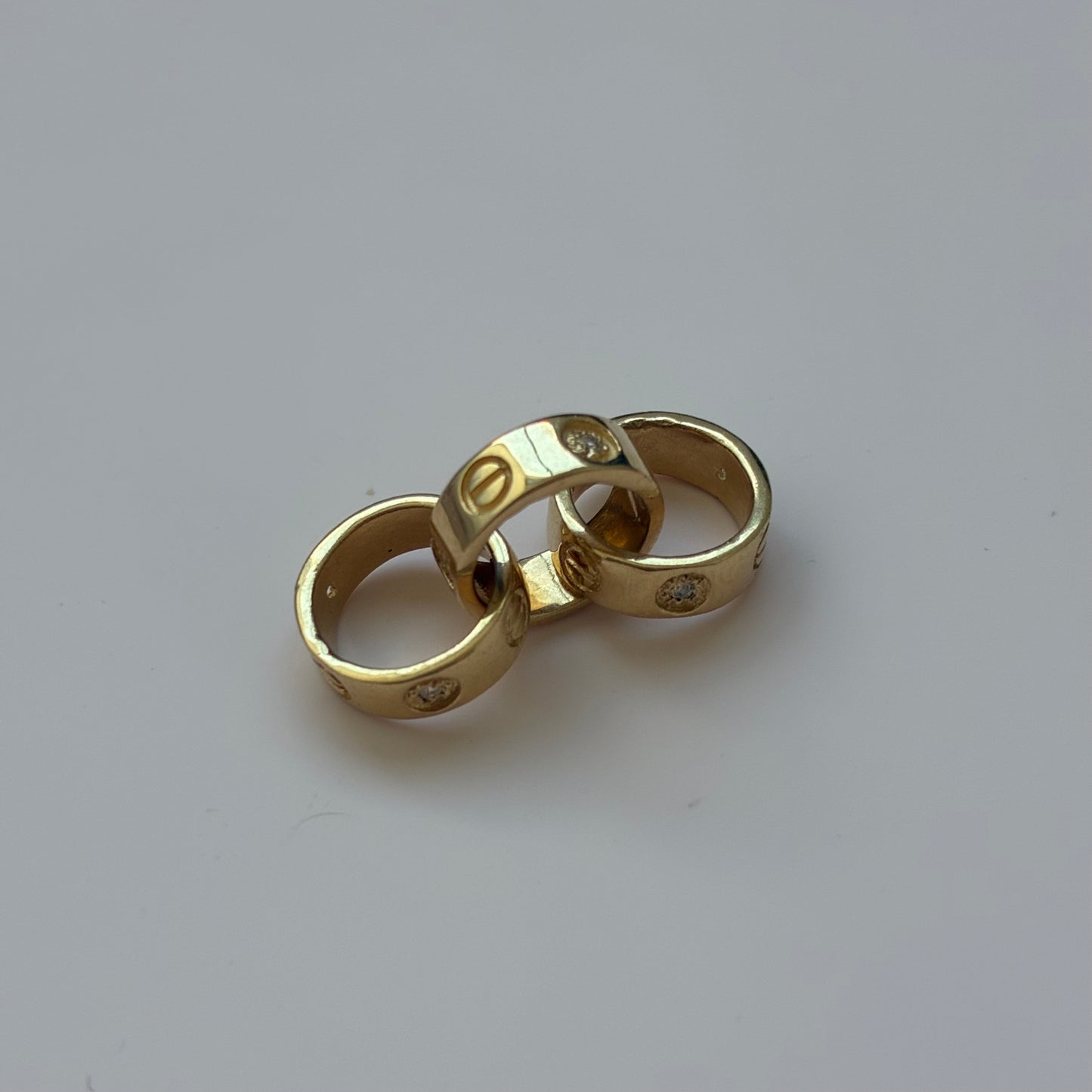 DIJE TRES AROS CT + PIEDRAS BLANCAS ORO AMARILLO 18K - 3,34GR