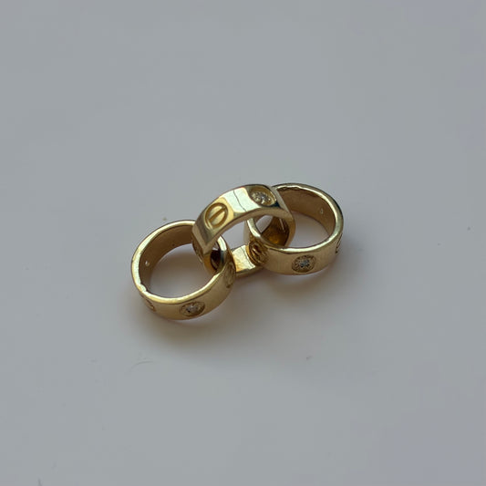 DIJE TRES AROS CT + PIEDRAS BLANCAS ORO AMARILLO 18K - 3,34GR